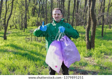 A man cleaning forest from the plastic, ecology of the environment, forest pollution, cleaning