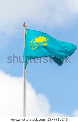 Flag of the Republic of Kazakhstan against the blue sky, wind.