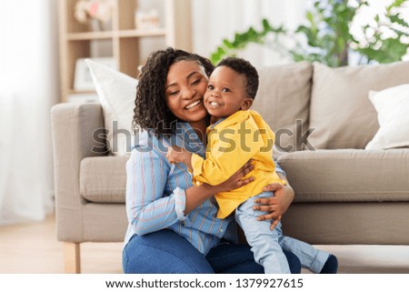 childhood, kids and people concept - happy african american mother with her baby son at home Royalty-Free Stock Photo #1379927615