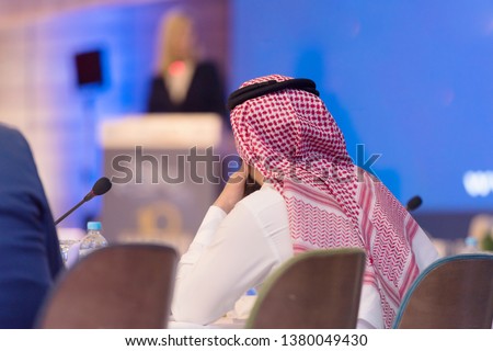 Business Conference and Presentation,Arabic businessman representing model of economic development and startup business, Audience at the big conference hall. Royalty-Free Stock Photo #1380049430