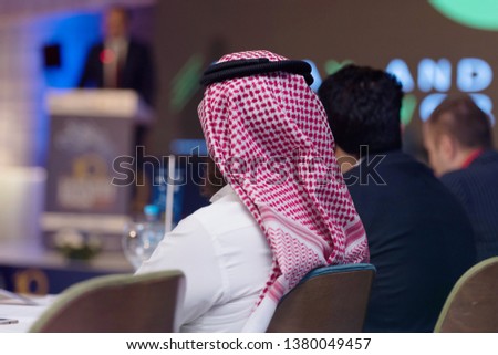 Business Conference and Presentation,Arabic businessman representing model of economic development and startup business, Audience at the big conference hall. Royalty-Free Stock Photo #1380049457