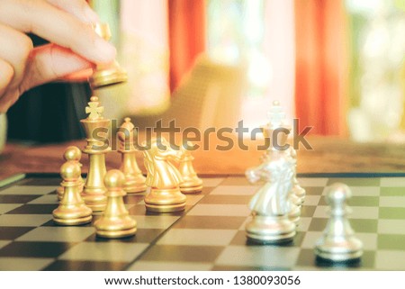 Gold horse in chess game face with the another silver team on black background (Concept for company strategy, business victory or decision) - Image