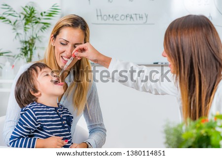 Homeopathy. Mother and little boy visiting a homeopath Royalty-Free Stock Photo #1380114851