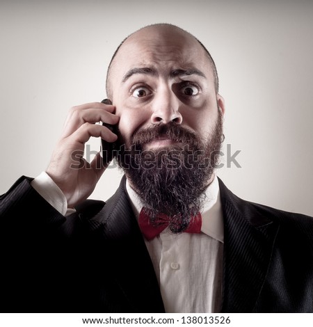  funny elegant bearded man on the phone on vignetting background