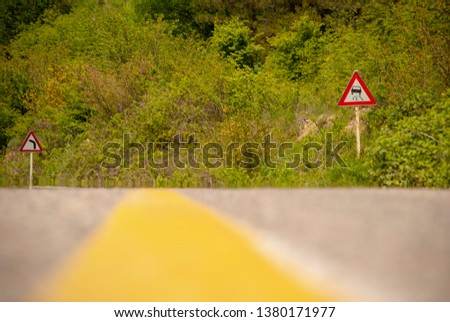 road signs warning drivers in jungle