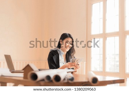 business woman with his hands raised while working on laptop with money rain