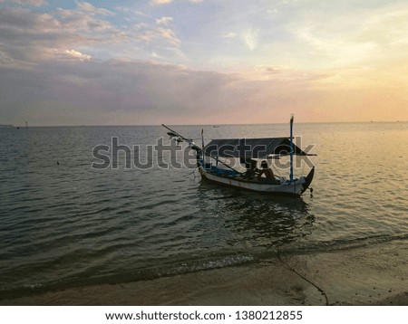 The view of the sea landscape with white clouds in the blue sky, the waves of the sea, the fishing boat park by the sea in the morning, the beautiful sea coast