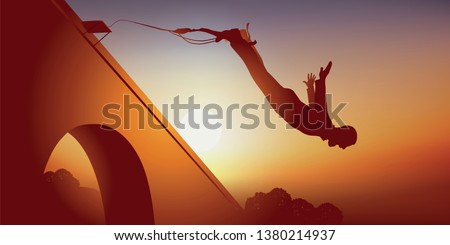 A man who loves extreme sport and thrills, throws himself off a bridge attached to a rubber band. Royalty-Free Stock Photo #1380214937