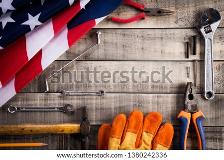 Labor Day, USA America flag with many handy tools on wooden background texture.