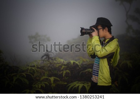 Tourists take pictures of scenery with mountain cameras in the morning mist.