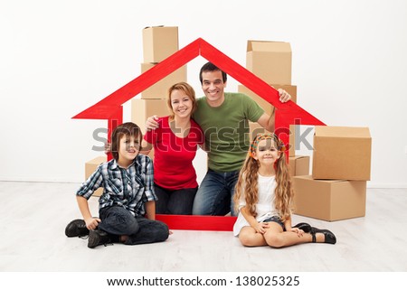 Happy family with kids moving into a new home - sitting with cardboard boxes