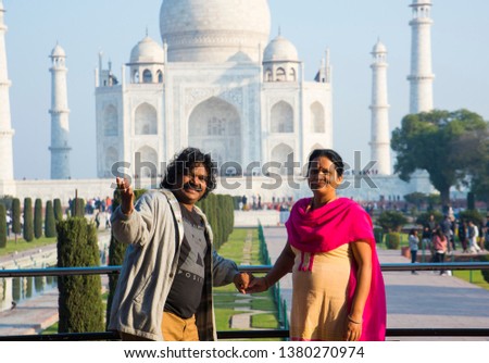 Romantic Indian couple in love embrace and enjoy the view of the Taj Mahal at Agra, India.
