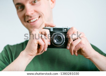 successful man taking pictures on the retro camera, studio photo on a black background