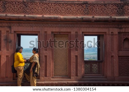 Romantic Indian couple seeing Taj Mahal from red fort, Agra, India.