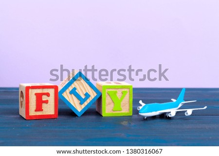 cube wooden block with alphabet building the word fly