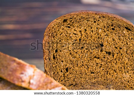 Freshly baked black rye bread, fragrant warm bread, was cut into pieces at home or in industrial production