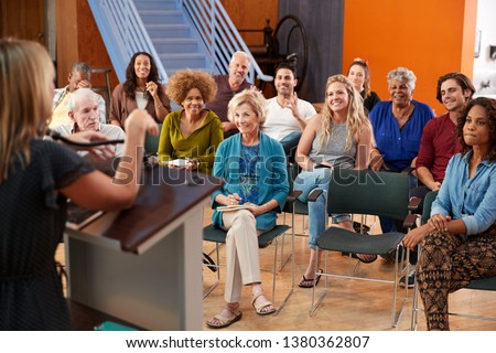 Group Attending Neighborhood Meeting Listening To Speaker In Community Center Royalty-Free Stock Photo #1380362807