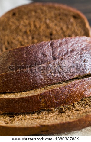 Freshly baked black rye bread, fragrant warm bread, was cut into pieces at home or in industrial production