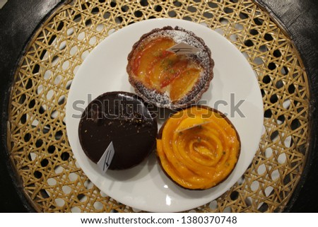 Delicious Tropical Tarts at Patisserie on Cane Woven Furniture in Dark Chocolate and Mango Flavours 
