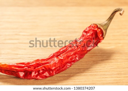 Close up cut dried red pepper on wooden cutting board. Shallow depth of field.