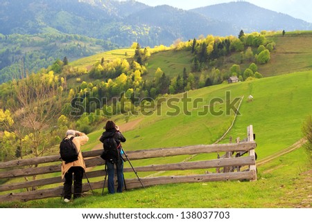 Photographers take pictures of spring rural landscape in the Carpathian mountains
