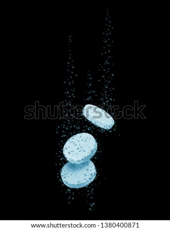 Three medical pills dissolves in water on a black background 