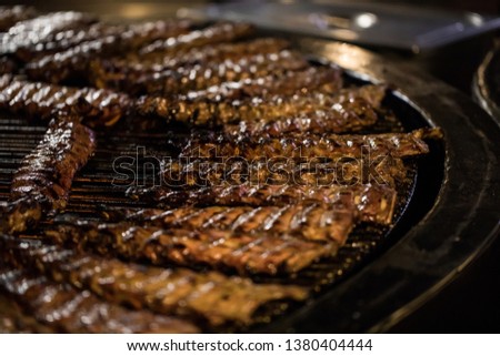 BBQ Roast Marinated Baby Back Pork Ribs Close-up On Hot Flaming Grill Background