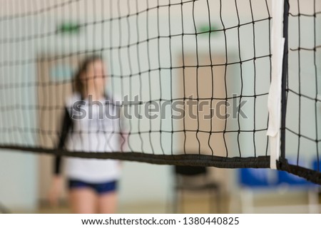 Volleyball net. In the background is a volleyball player, a girl Royalty-Free Stock Photo #1380440825