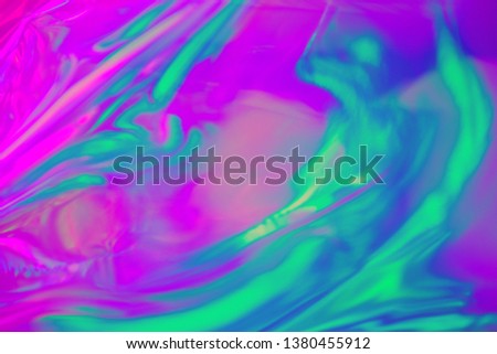 Abstract trendy holographic background in 80s style. Real texture in violet, pink and mint colors with scratches and irregularities. 