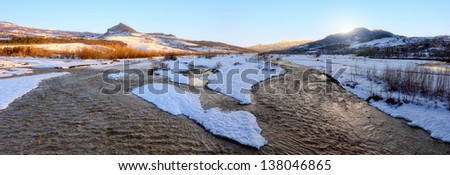 wide river with snow and ice at sunset