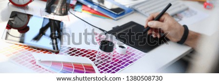 Designer male arm hold graphic pad pen working on project at home computer closeup background