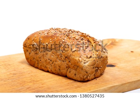 rustic homemade bread with sunflower seeds on a wooden board, isolated