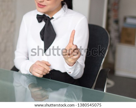 Businesswoman showing index finger in office, business opportunity