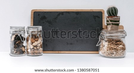 Banner. Black board, cactus, cutting board, glass jars with dried fruits, nuts and muesli.