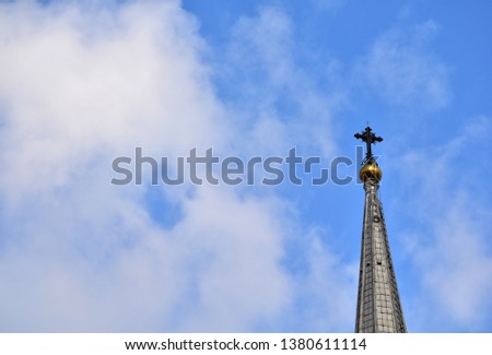 Church Roof with a cross. Church building roof with holy cross. Cloudy moody sky background. Minimal architecture design and detail. Exterior design and detail. Abstract architecture.