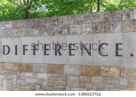 Difference text with a dot (.) on old stone wall brick at public park in America. Concept image texture