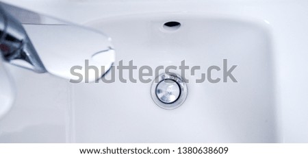 Open chrome faucet, tap washbasin in light room