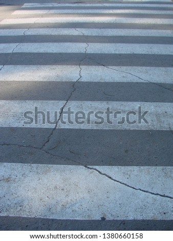 Zebra crosswalk on the road for safety when people cross the street.