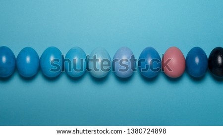 Creative Easter concept. Row Colorful Easter eggs of a blue gradient on a blue background. View from above
