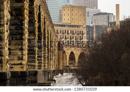 cityscape of historic architecture along river in Minneapolis, with newer architecture in the background.