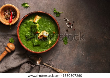 Palak paneer or Spinach and Cottage cheese curry,mortar with spices on a dark background. Traditional Indian dish. Top view, copy space Royalty-Free Stock Photo #1380807260