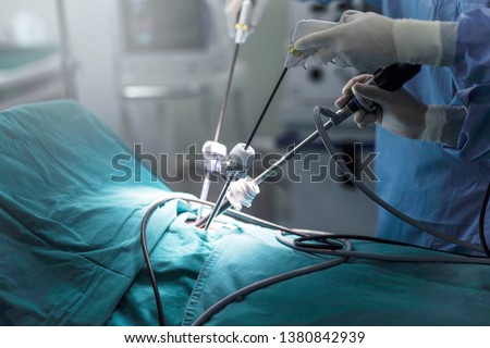 The surgeon's holing the instrument in abdomen of patient. The surgeon's doing laparoscopic surgery in the operating room. Minimally invasive surgery. Royalty-Free Stock Photo #1380842939