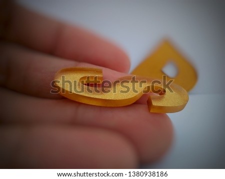 the letter "S" above the hand, the background looks blurry