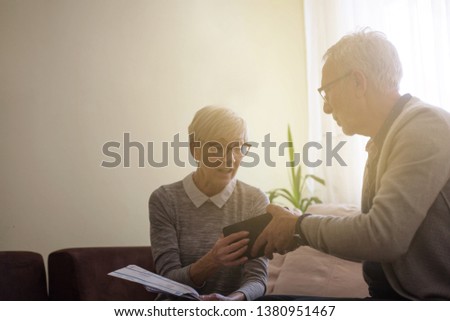Senior couple holding empty wallet.