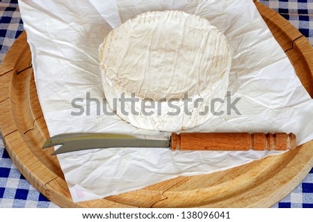 Whole French Camembert on a round wooden chopping board. Royalty-Free Stock Photo #138096041