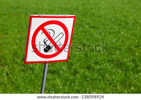 No smoking sign on green grass background