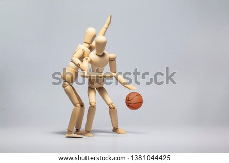 Wooden mannequin with basketball ball on gray background