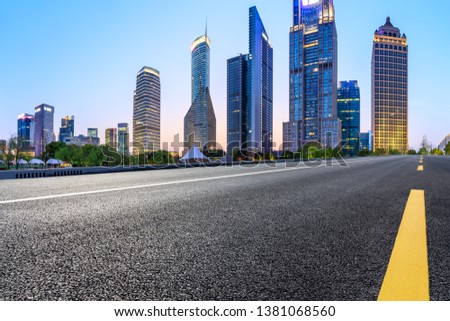 Shanghai modern commercial office buildings and empty asphalt road at night