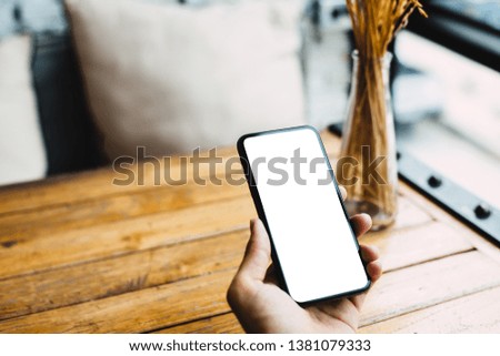 Close-up image of hands using smartphone mockup at the white,Blank screen smartphone for graphic display-photo,Blurred Background. -Image