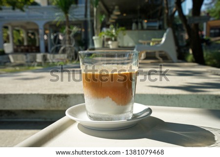 Close up glass of latte coffee with sunlight and shadow